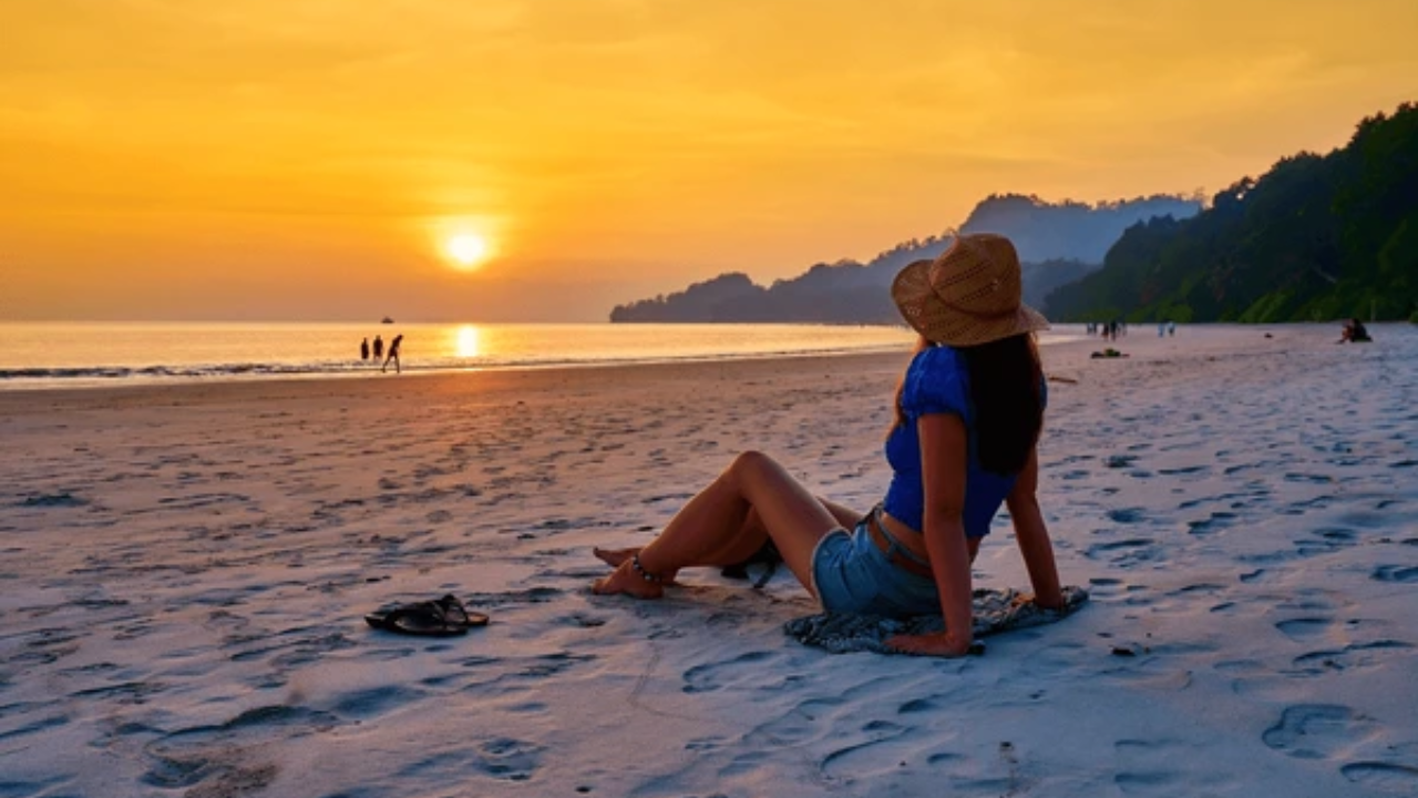Woman enjoying a serene sunset view at Radhanagar Beach in Andaman