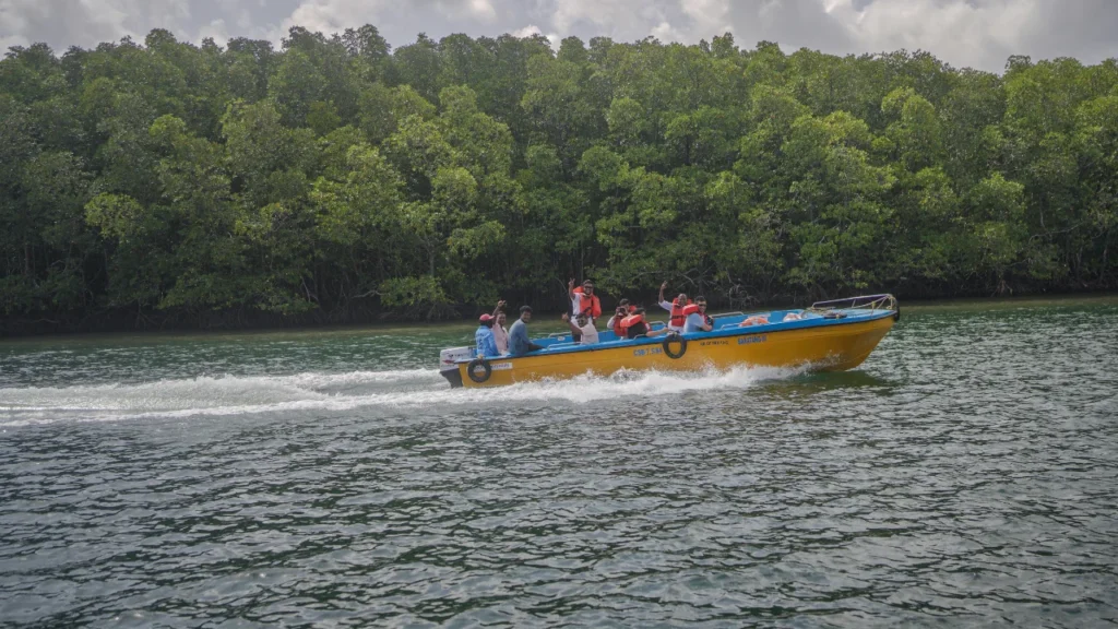 A family enjoying a thrilling speedboat ride through lush green mangroves during their vacation in the Andaman Islands.
