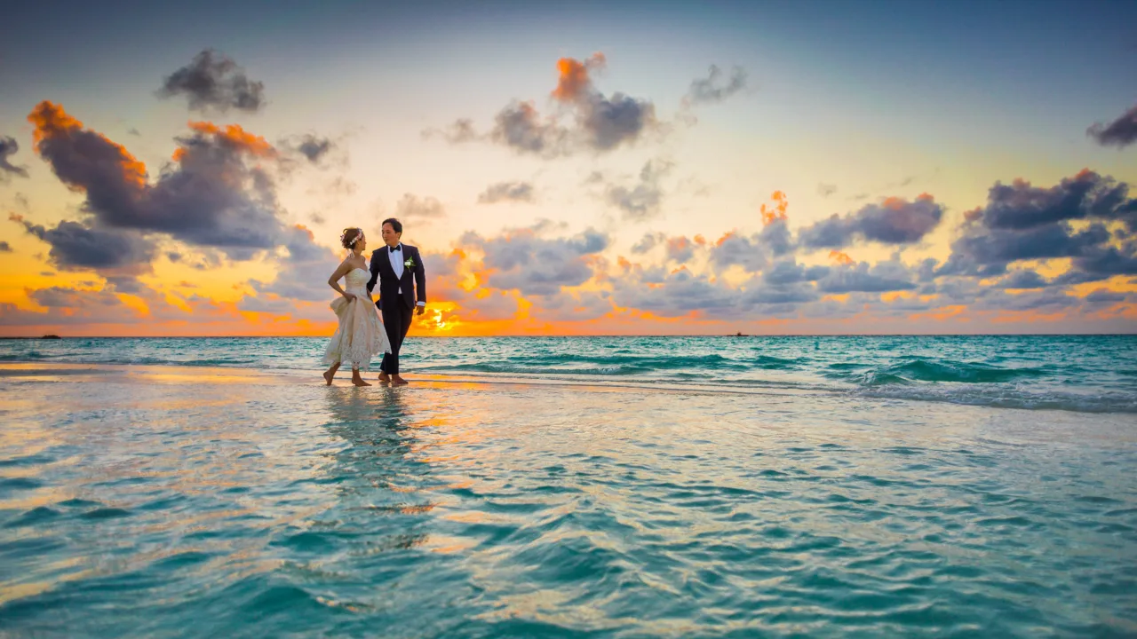 Newlywed couple walking on the beach at sunset during Andaman honeymoon trip

